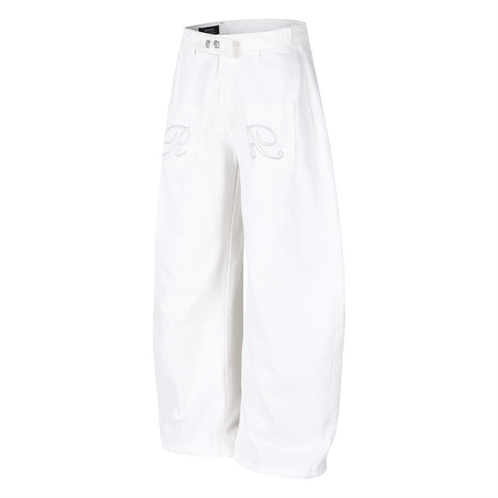 Angled front view of white baggy barrel-leg jeans with wide legs and embroidered pockets