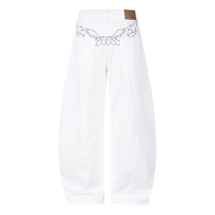 Back view of white wide-leg jeans featuring a large embroidered wing design across the waistband