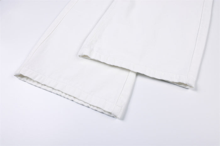 Close-up of the white jeans’ wide-leg hems showing stitched edges and layered fabric