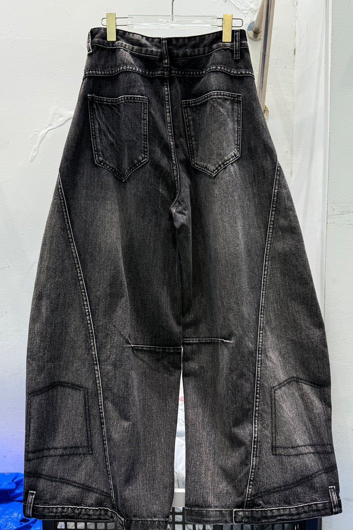 Back view of black washed wide-leg jeans with two patch pockets and stitched lower-leg panels