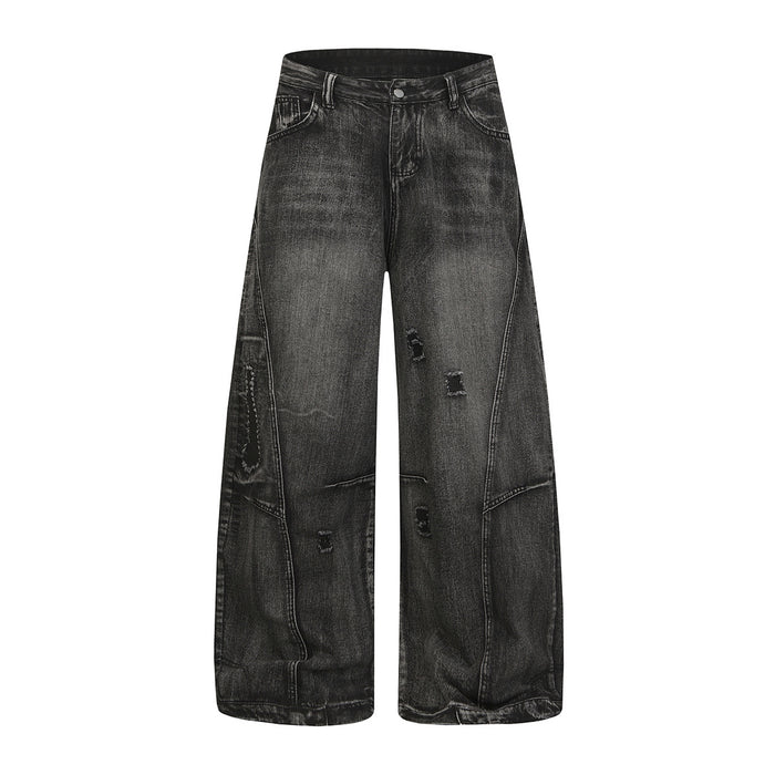 Full front view of black washed baggy jeans with wide legs, distressed rips, and utility pocket details