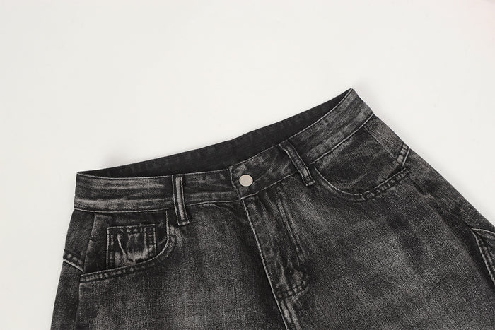 Close-up of the jeans waistband, belt loop, button closure, and front pocket in washed black denim