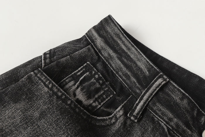 Close-up of a front pocket, belt loop, and textured washed black denim waistband