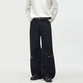 Black men's wide-leg cargo pants with rivet stud hardware, zipper accents, and multiple cargo pockets, front view