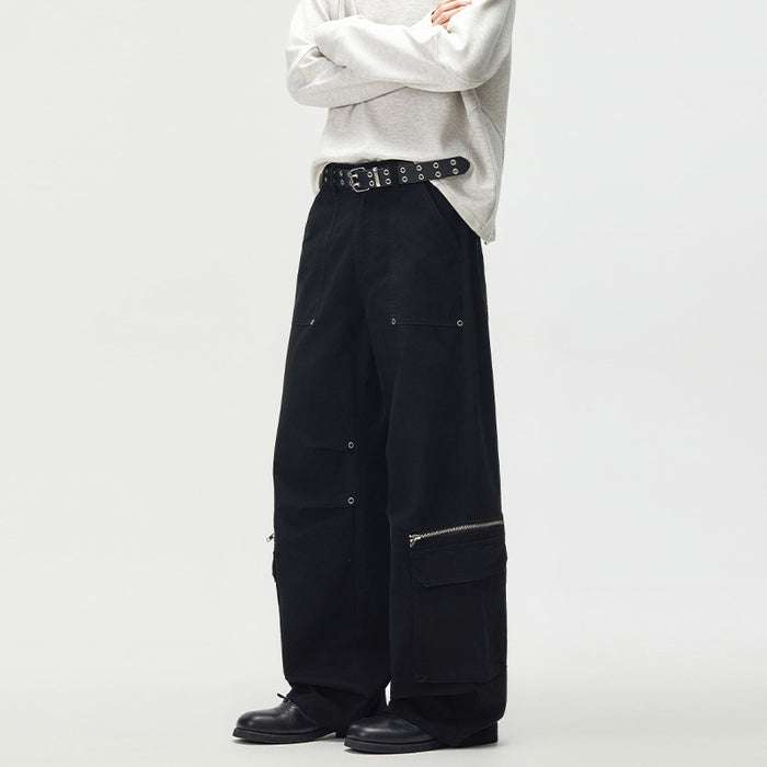 Black wide-leg cargo pants shown from the side, with roomy legs, layered cargo pockets, and silver zipper accents