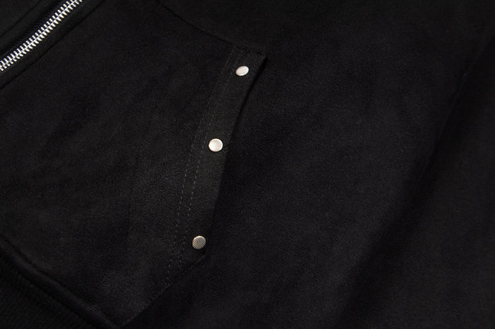 Close-up of a black hoodie front pocket flap with three round silver snap fasteners