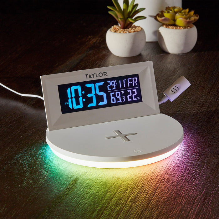 Close up of the mood light weather station showing large blue digits on a white housing beside succulent planters