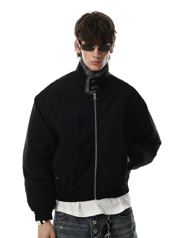 Model wearing a black padded bomber jacket with a raised gray faux fur collar and zip front