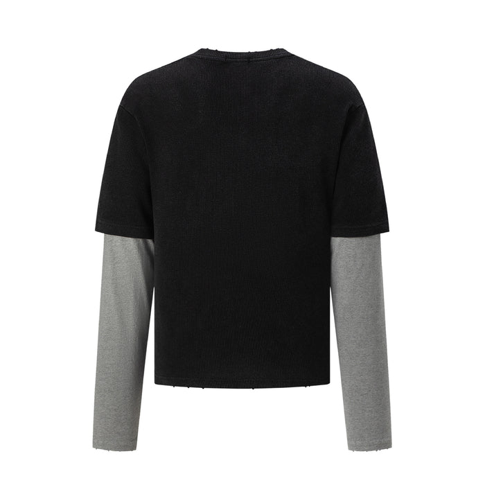 Back view of the black waffle knit shirt with short sleeves over contrasting gray long sleeves