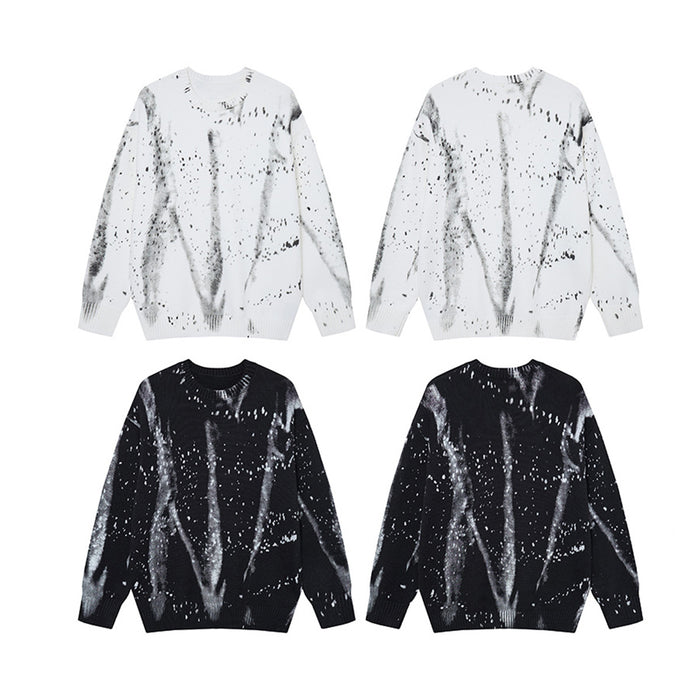 Four black and white crew neck sweaters arranged together, showing both color options and paint splatter designs