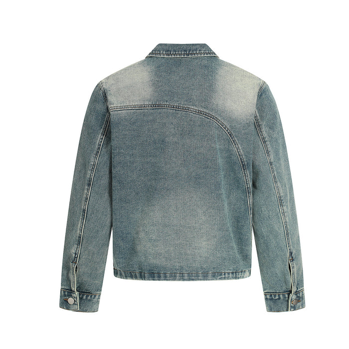 Back view of a light wash denim jacket with curved yoke seam, long sleeves, buttoned cuffs and distressed fading