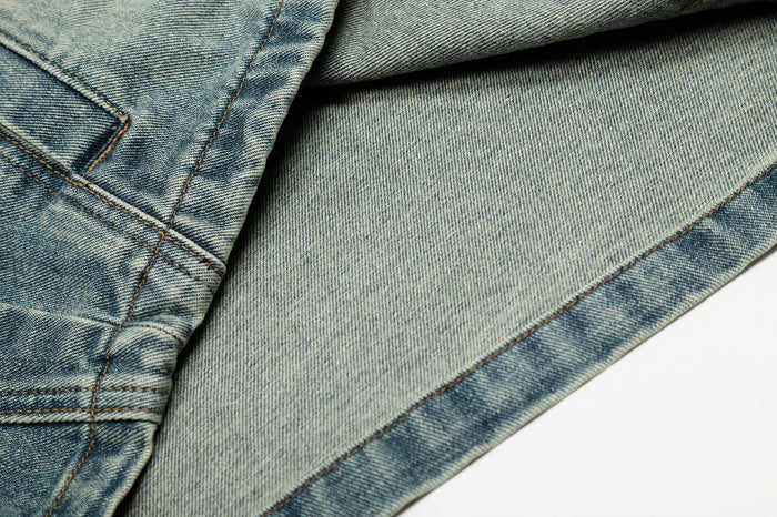 Inside detail of the denim jacket showing the lighter inner fabric, stitched seam and finished hem edge