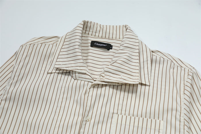Close-up of the cream striped shirt collar, button placket, shoulder seams, and chest pocket