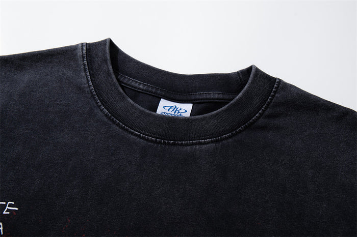 Close-up of the black T-shirt's ribbed crew neckline, double stitching, and inner label