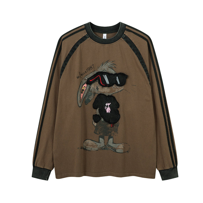Washed long sleeve graphic tee with cartoon rabbit print, embroidered patch, and contrast raglan stripes in khaki brown
