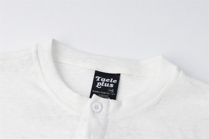 Close-up of the white Henley collar, top button, and sewn neck label