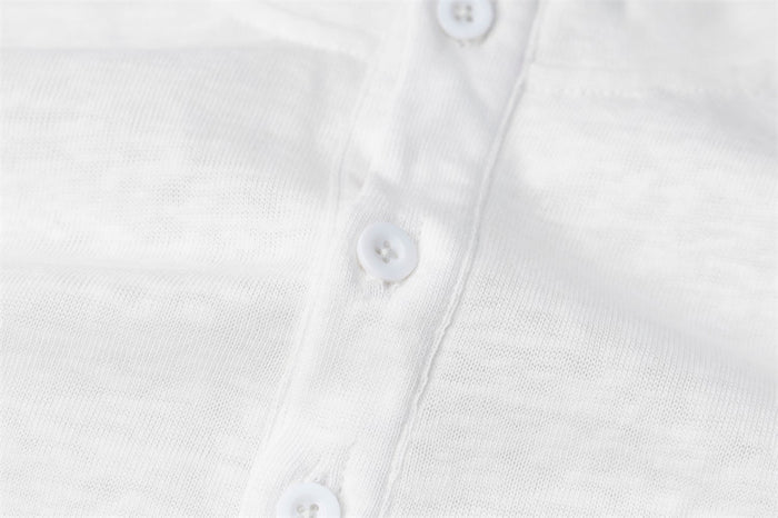 Close-up of the white Henley placket showing three white buttons and fine fabric texture