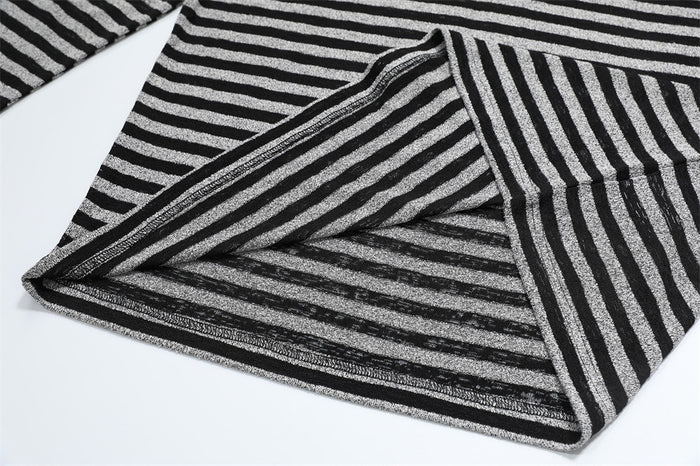 Close-up of the shirt hem turned upward, showing the striped inner fabric and finished seam