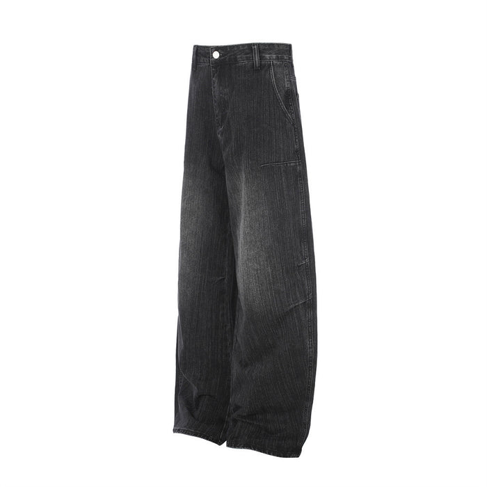 Angled side view of black washed denim jeans showing the wide barrel leg and curved outer seam