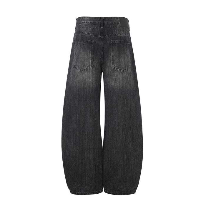 Back view of black barrel-fit jeans with two patch pockets and rounded wide legs