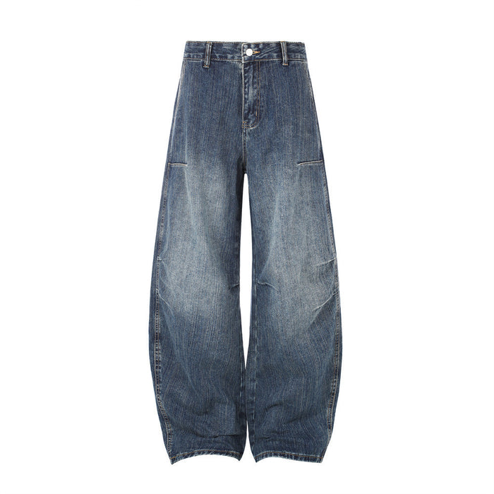 Front view of washed blue wide-leg barrel jeans with curved seams and faded thigh panels