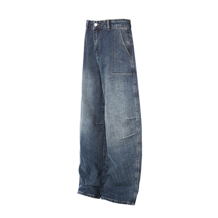 Angled side view of washed blue denim jeans showing the wide curved leg and side patch pocket