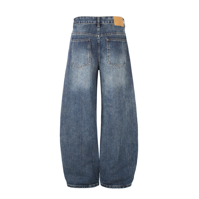 Back view of washed blue barrel-fit jeans with two outlined patch pockets and a tan waistband label