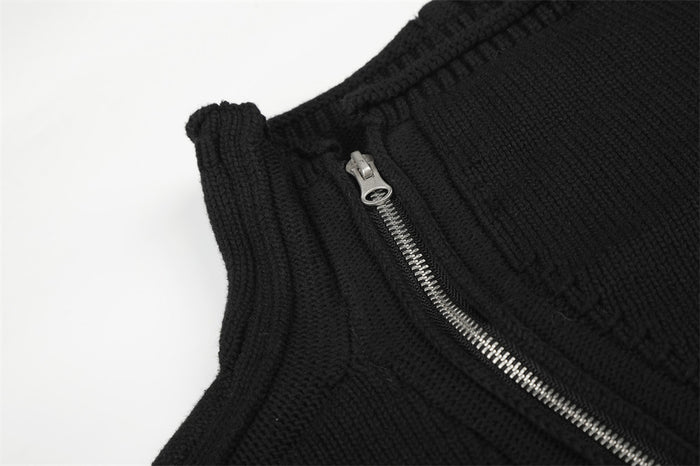 Detailed view of the black high collar and silver zipper teeth on the knit jacket front