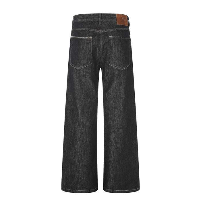 Back view of black wide-leg denim jeans with two outlined rear pockets and a brown waistband patch