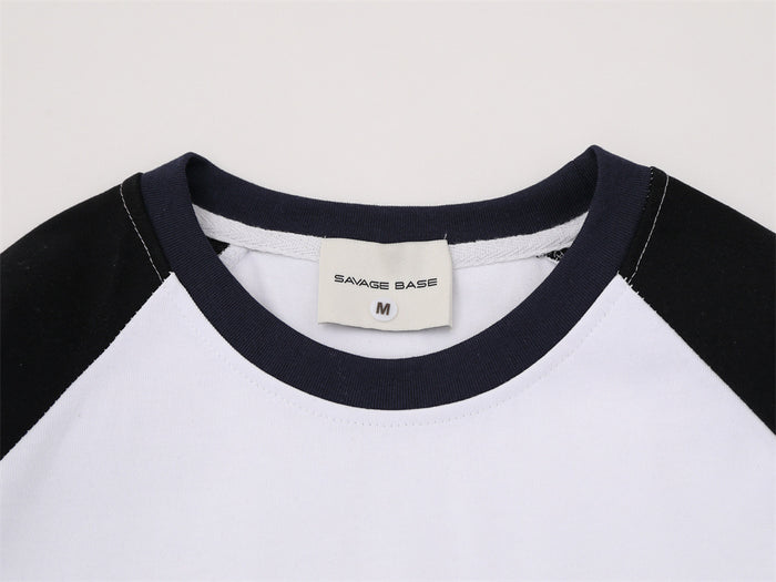 Close-up of the white tee neckline showing its dark ribbed collar and sewn size label