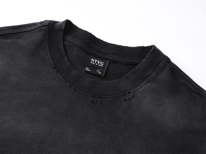Close-up of the black shirt's ribbed crew neckline, stitching, and sewn-in label