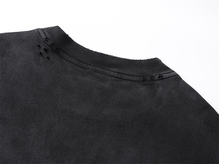 Close-up of the black shirt collar showing faded fabric and small distressed holes