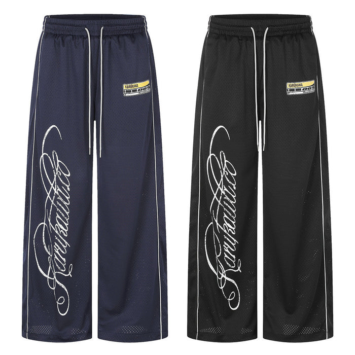 Front view of navy and black wide-leg mesh pants with elastic drawstring waists, white piping and script graphics