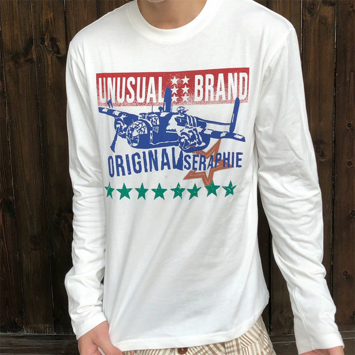 Model wearing a white long-sleeve shirt with a colorful fighter jet graphic and star print