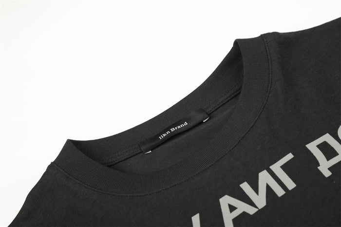 Close-up of the black crew neckline, inner label, and partial gray Cyrillic lettering on the shirt