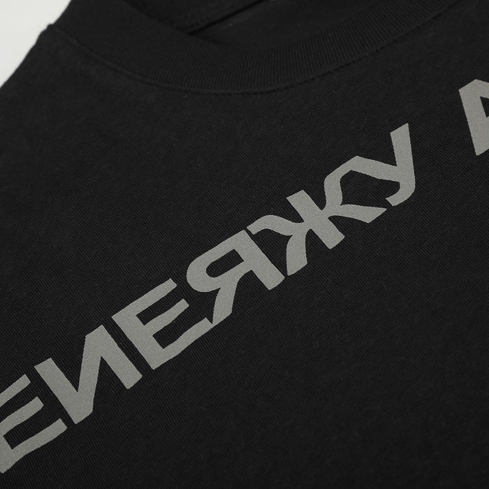 Close-up of gray Cyrillic lettering printed across the textured black T-shirt fabric below the collar