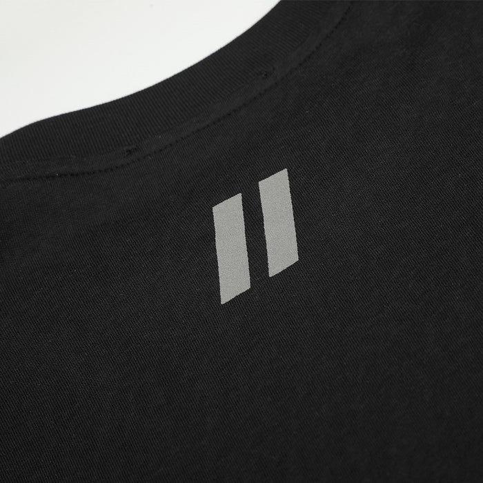 Close-up of the small gray two-bar graphic beneath the ribbed crew neckline on black fabric