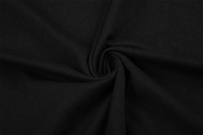 Close-up of the black T-shirt fabric gathered into a twist, showing its fine textured knit surface