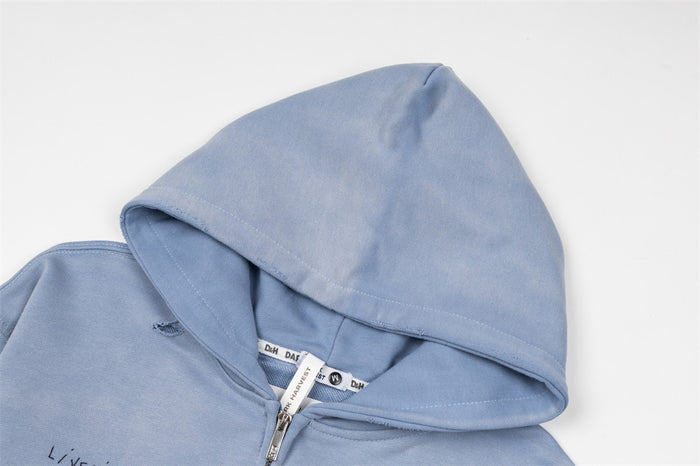 Close-up of the washed light blue hoodie showing the hood opening, seam, and neck label