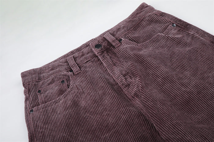 Close-up of the mauve corduroy waistband, belt loops, front pockets, button, and fly seam