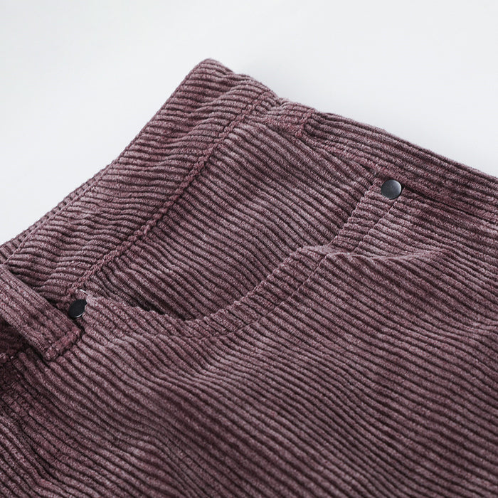 Detailed view of a mauve corduroy front pocket with a black button and pronounced ribbed texture
