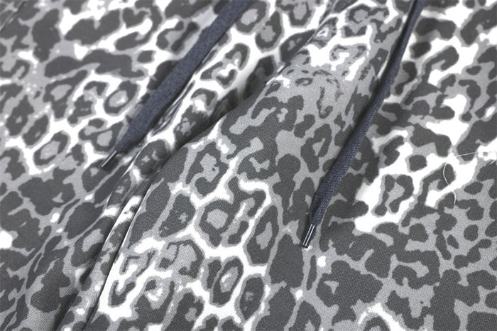 Close-up of dark drawstring cords against the grey leopard-print fabric