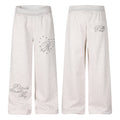 Men's heather grey wide-leg sweatpants with 3D script R embroidery and silver dome studs on left thigh, front and back view