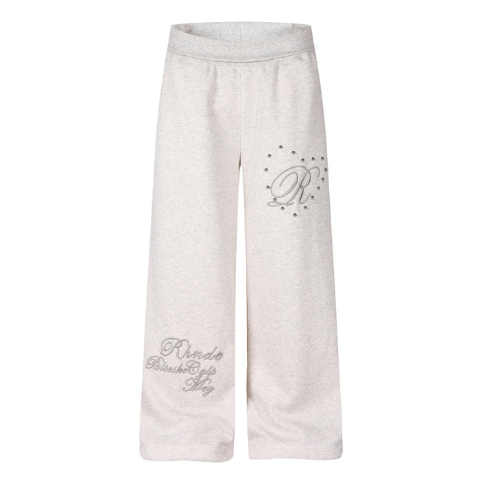 Light gray wide-leg sweatpants front view with script embroidery and a studded monogram design