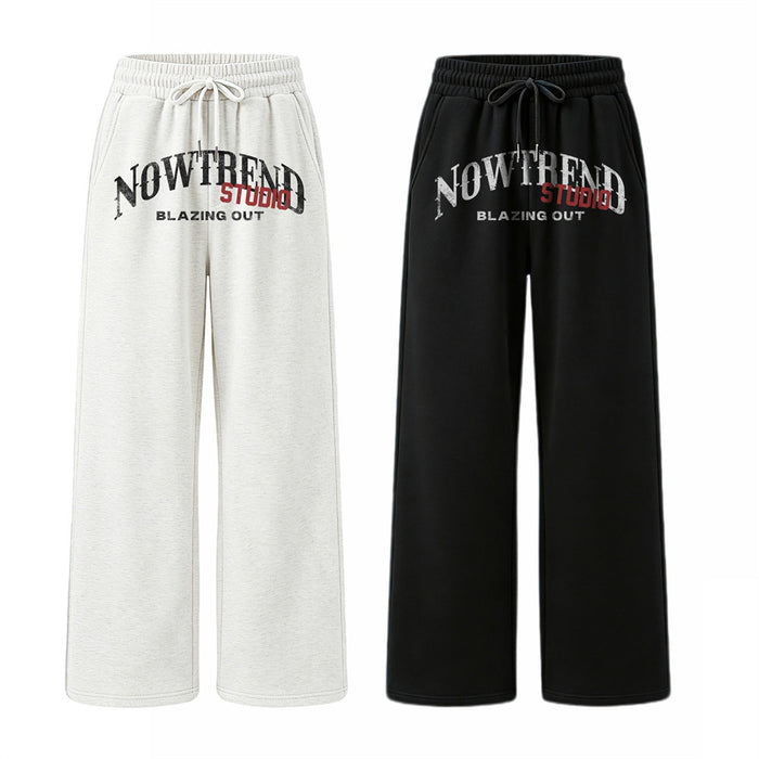 Front view of wide-leg sweatpants in white and black with elastic waists, drawstrings, and graphic prints
