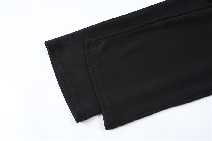 Close-up of black wide-leg sweatpants hems showing the straight lower edges and stitched seams