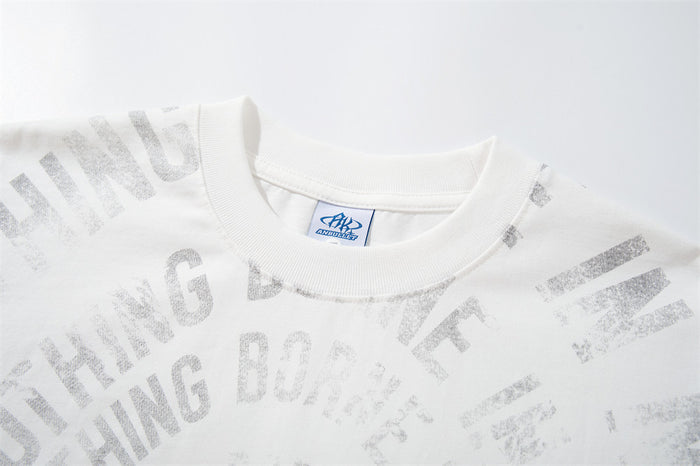 Close-up of the white shirt’s ribbed crew neckline and pale gray distressed text print