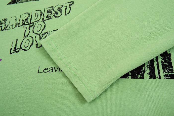 Close-up of green polo shirt fabric and sleeve edge overlapping the printed chest design