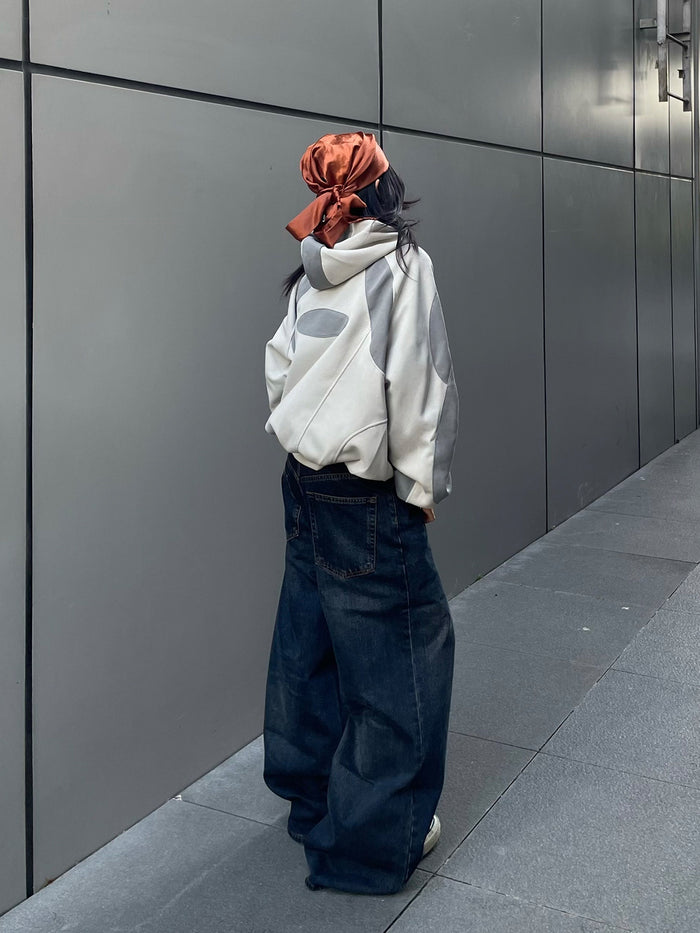 Back-side model view of the oversized gray patchwork hoodie with hood and rear oval panel