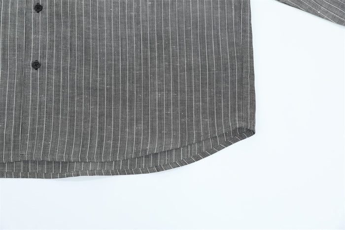 Close-up of the gray pinstripe shirt curved hem and lower front button placket